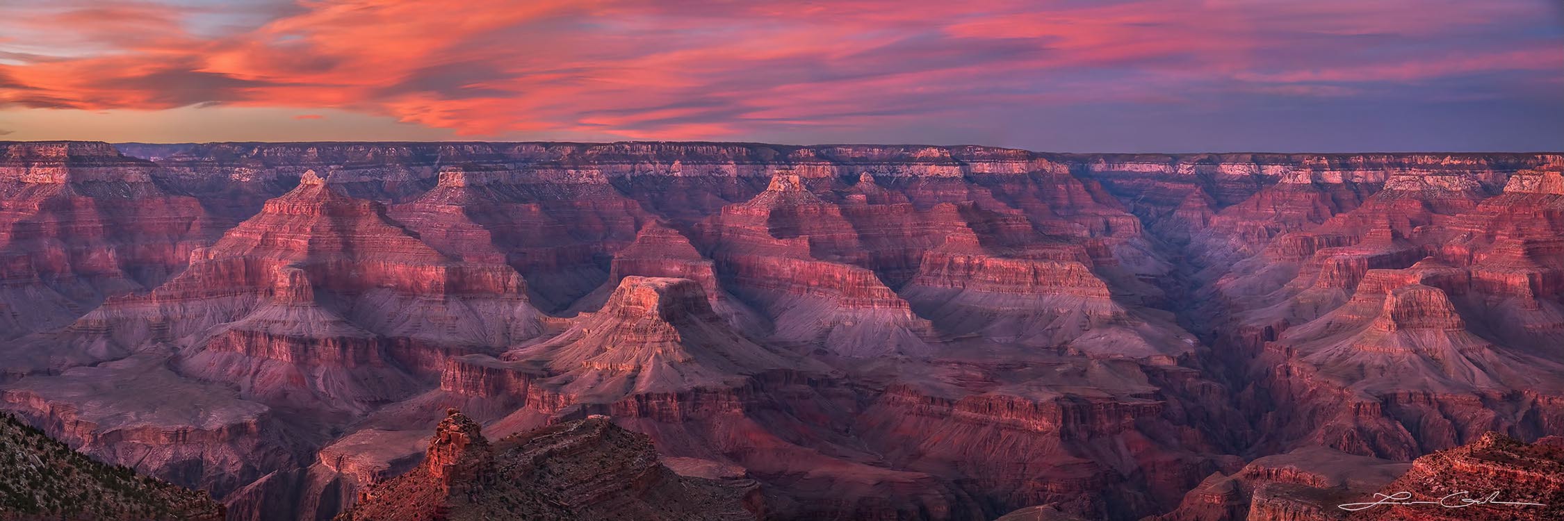 A beautiful sunset panorama of the Grand Canyon with pink clouds above
