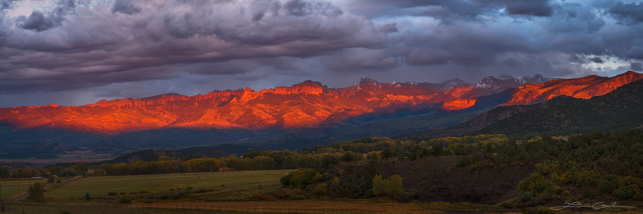 Red mountains covered with saturated sunset light panorama in Colorado
