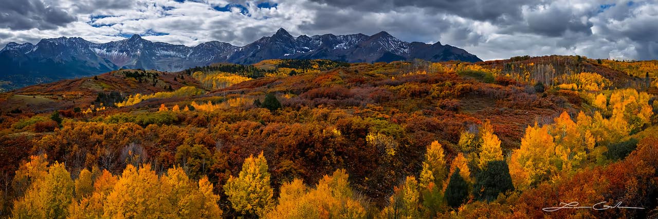 Orange aspens and fall color shrubs with Colorado mountains in the background - Small
