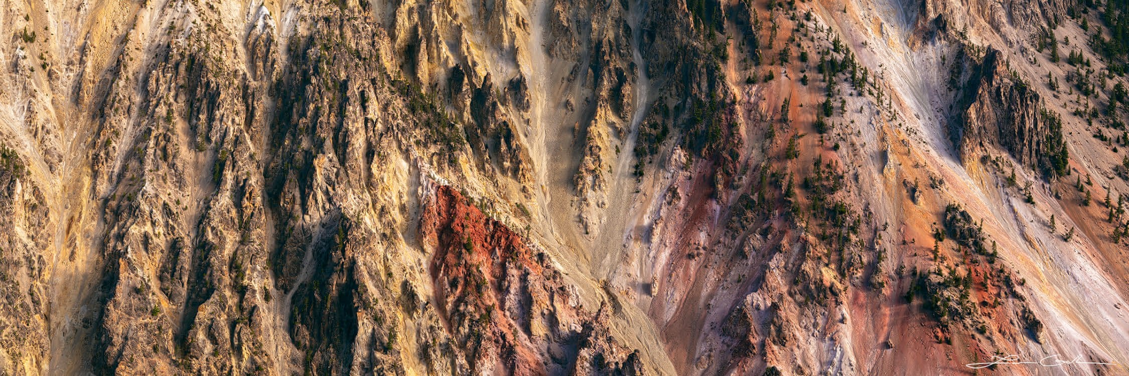 A panoramic abstract of a big canyon wall with yellow, orange, and pink colors, Yellowstone National Park
