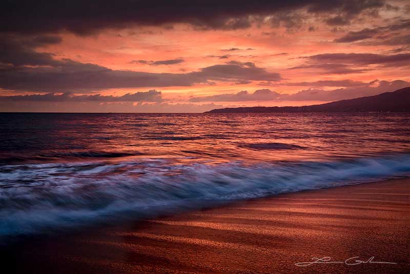 An ocean wave under a crimson red sunset and sky with clouds and red sand, Mexico - Small