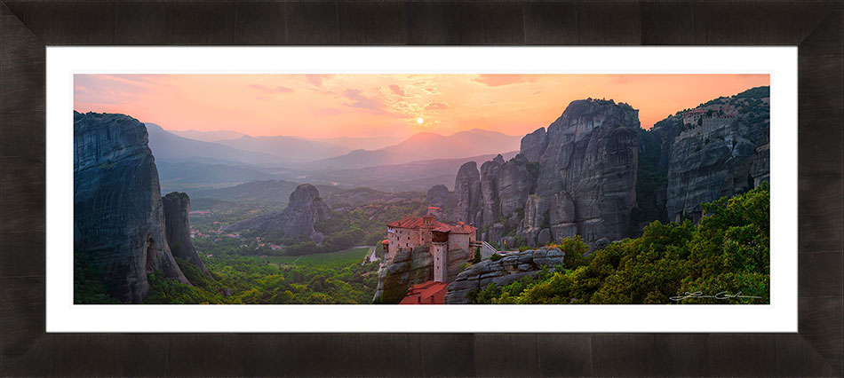 A framed print of Meteora Greece with a sunset and monasteries - white liner