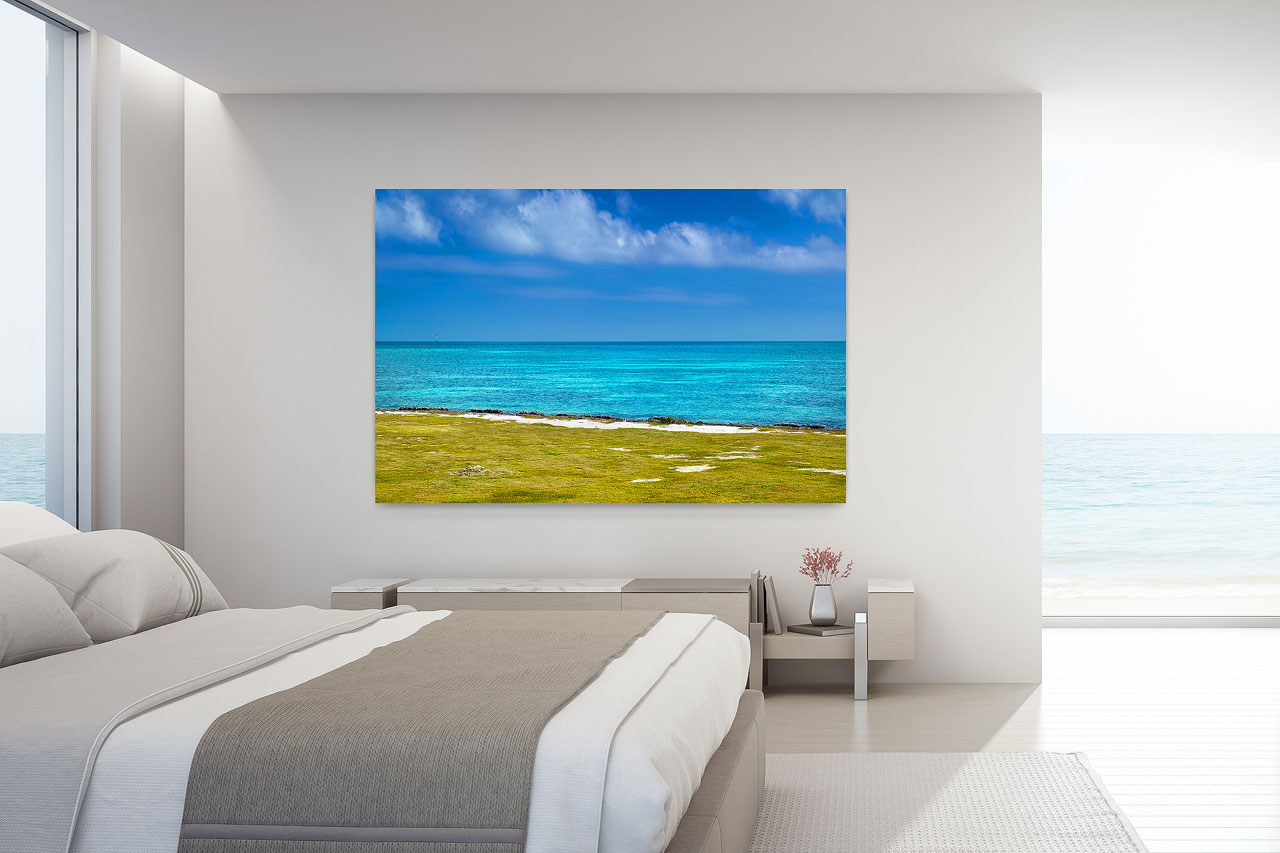 Interior design with large format photography showcasing a contemporary wall art print of a calm turquoise ocean inside a modern bedroom - Gintchin Fine Art