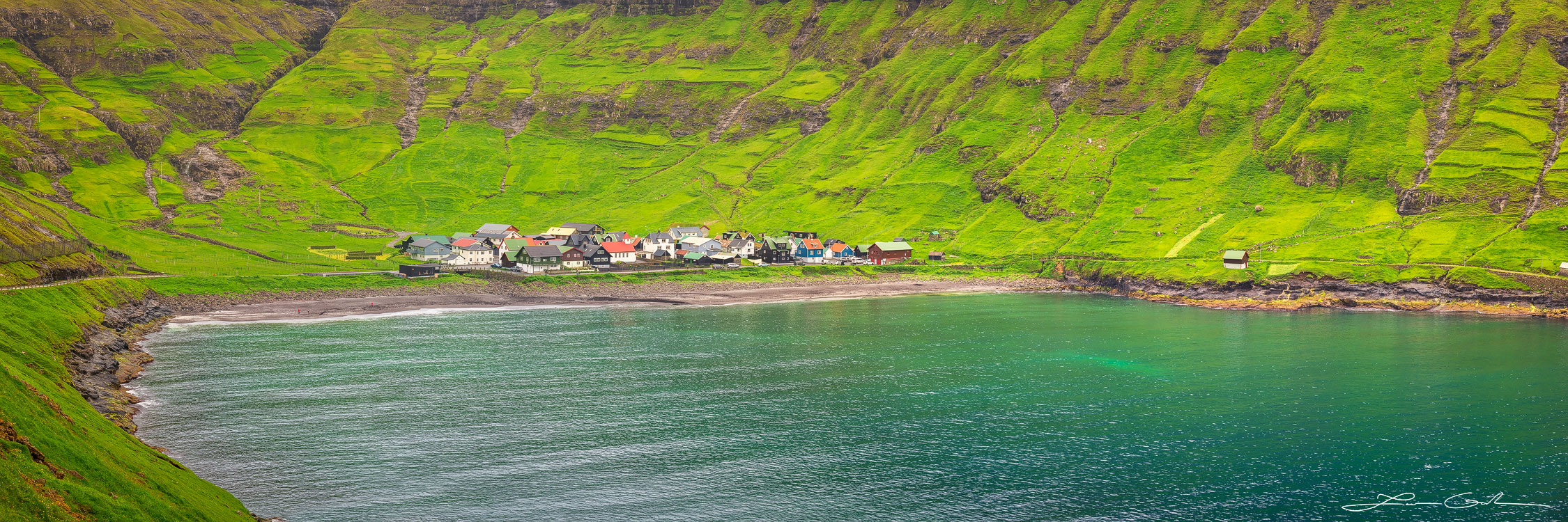 A fairytale looking like village nestled at the end of a fjord and surrounded by green lush mountains - Faroe Islands - Gintchin Fine Art