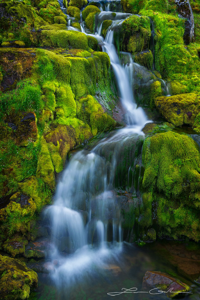 A beautiful slow motion waterfall with lush green moss all around it - Faroe Islands - Gintchin Fine Art