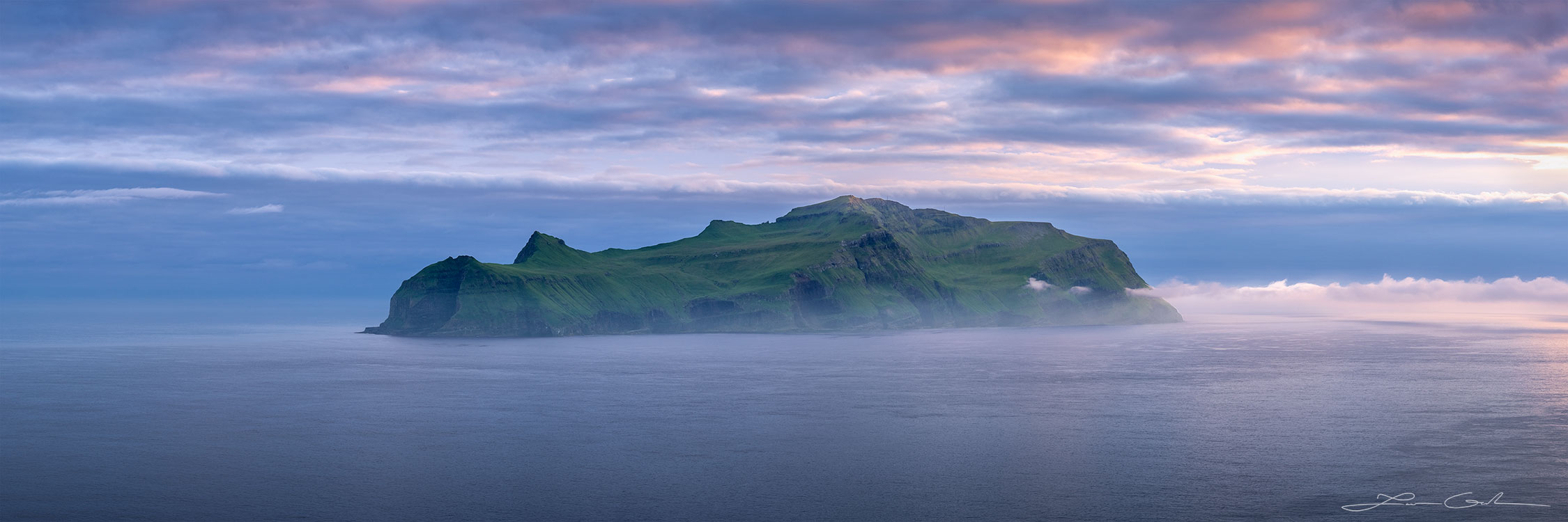 A late sunset with some pink and blue clouds above a panoramic island in the middle of the ocean - Faroe Islands - Gintchin Fine Art