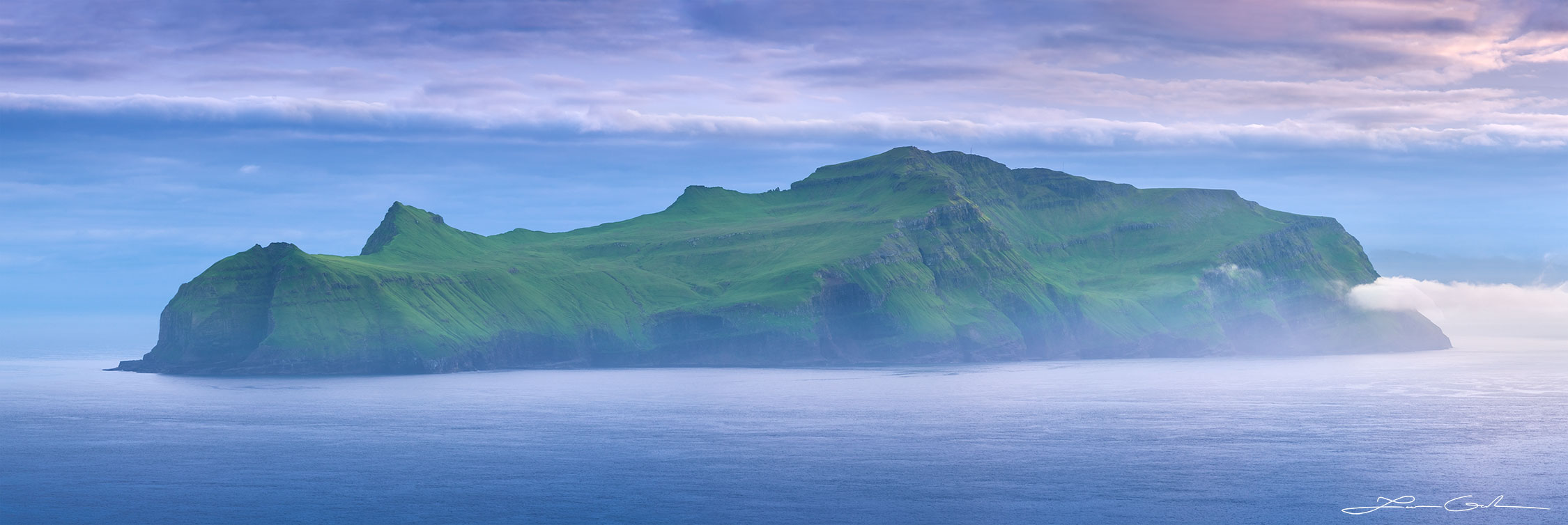 an evening panorama of a long island with some mist and clouds around - Faroe Islands - Gintchin Fine Art