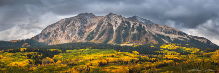 A striking panorama of fall color aspen trees, a mountain, and clouds - Gintchin Fine Art