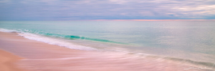 A beautiful panorama with a calm ocean and beach waves foaming at the shore - abstract photo - Gintchin Fine Art