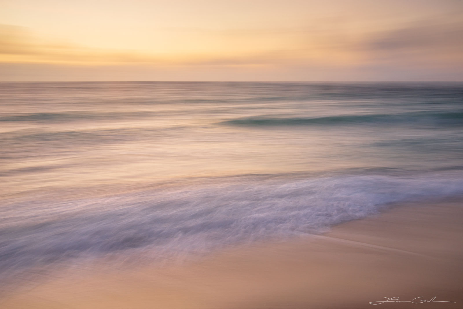 Pastel colors over an ocean shore with some waves and a sandy beach - Gintchin Fine Art