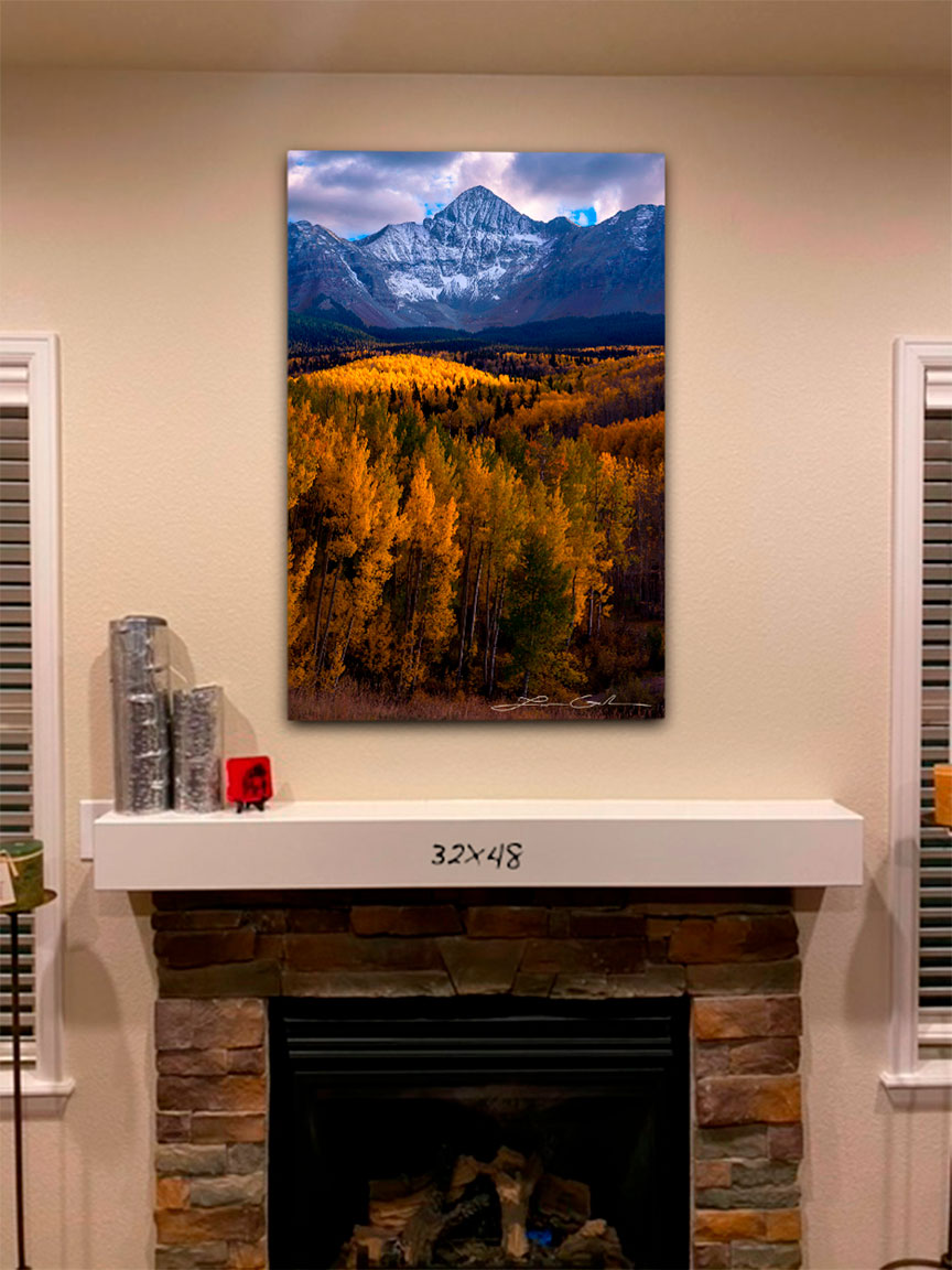 A print of Wilson Peak over a fireplace - Gintchin Fine Art