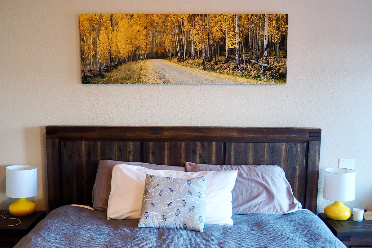 A beautiful fall color aspen scene panoramic photo print on a wall in a master bedroom - Gintchin Fine Art.