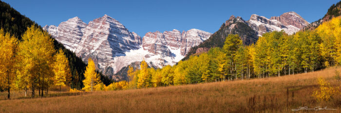 A unique panoramic view of the Maroon Bells peaks near Aspen, Colorado with golden aspen trees during the fall and fresh snow on the mountains