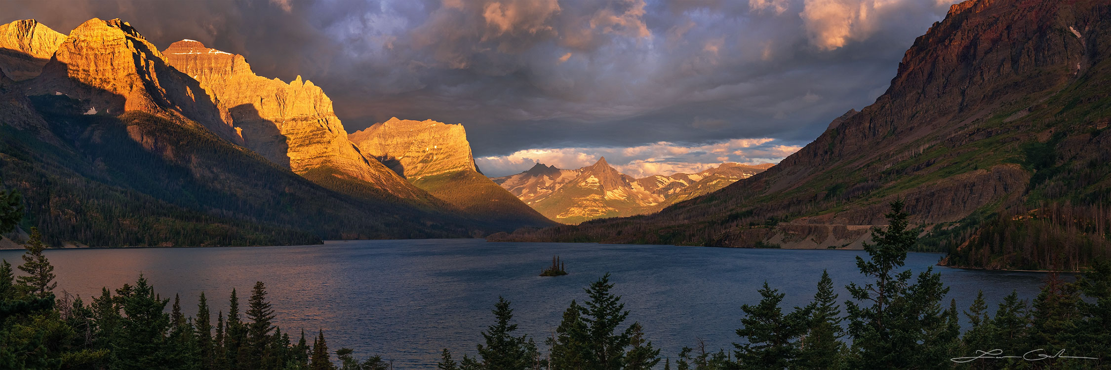 A panorama of Glacier National Park, Montana at sunrise with St Marys lake with dramatic light and stunning peaks - Gintchin Fine Art