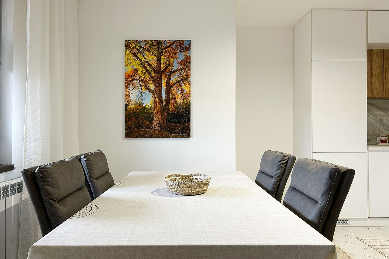 A vertical print of a fall colors cottonwood on the wall of modern dining room - Gintchin Fine Art