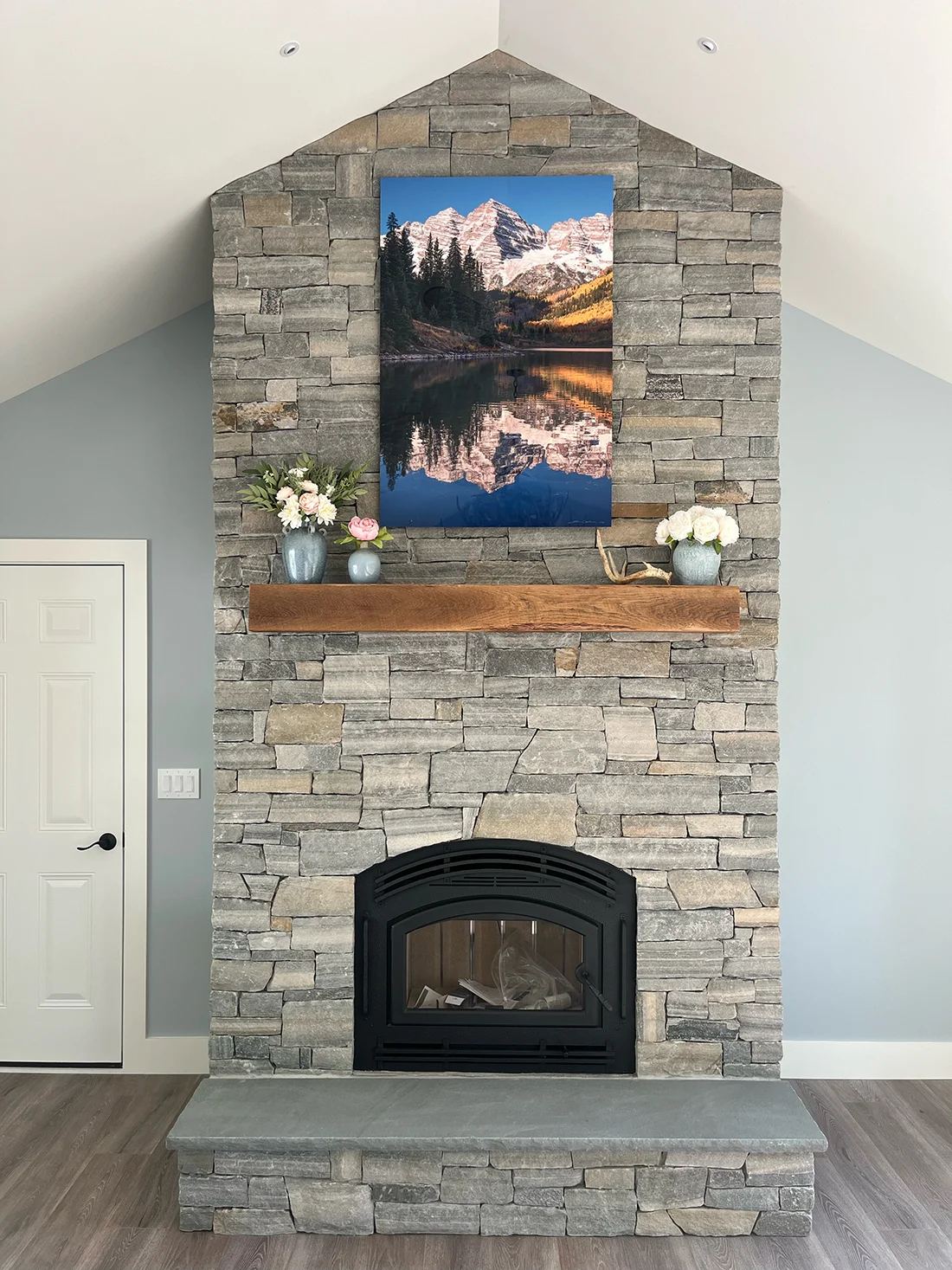 A large format print of Maroon Bells, Colorado, hanging over a fireplace - Gintchin Fine Art