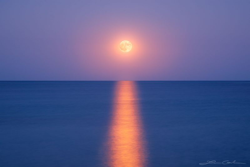 A beautiful full moon at a moonrise over the ocean/sea horizon - Gintchin Fine Art